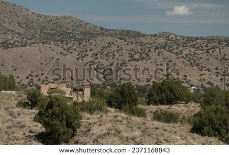 Weathered shack surrounded by dry hills just to the north of Madrid, New Mexico Royalty-Free Stock Photo #2371168843