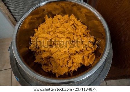 Homemade tortilla chip snack that has been fried and ready to be packaged, pictured with a flat lay concept. The tortilla chips are fried golden yellow and very crunchy