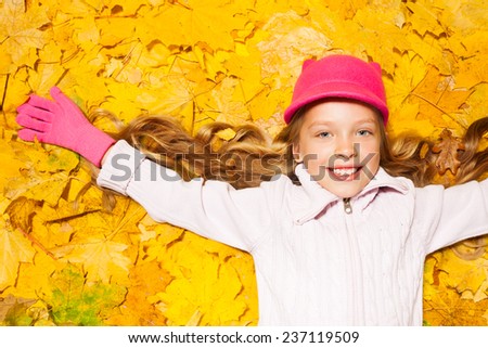 Happy smiling girl on autumn leaves 