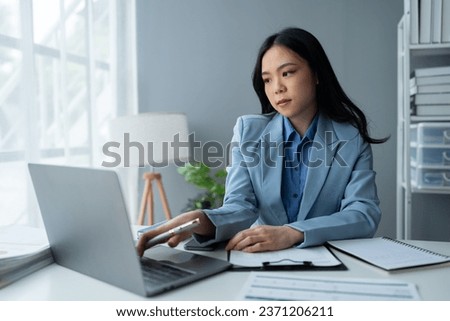 Asian businesswoman uses laptop computer with documents The notebook is on the table. Planning to analyze the report Financial statistics Investments, business plans, ideas, startup businesses.