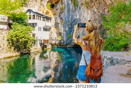 Woman tourist taking photography in Bosnia and Herzegovina- Blagaj house, cave and river