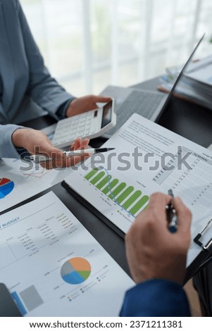 team work process Business team use calculator to calculate figures, business statistics, profit, cost analysis, growth rate graph document. data charts on the desk Royalty-Free Stock Photo #2371211381