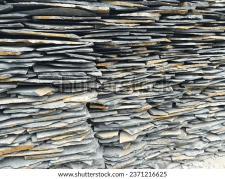 A pile of natural rock slabs ready for sale which are usually used as decorative layers to cover fence walls or houses