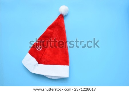 Santa claus red wool winter hat with reindeer print on blue background, christmas decoration