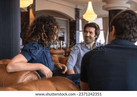 Entrepreneurs talking relaxed sitting on comfortable couch during a business meeting in a hotel