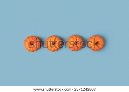 Creative Top view autumn composition. Frame of small pumpkins on a blue paper background. Template fall harvest thanksgiving, anniversary invitation card. Halloween pumpkin flat lay. Horizontal Banner