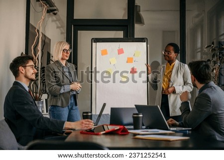 Inclusive corporate culture on display as a varied group of professionals in a conference room, exchanging insights during a collaborative meeting