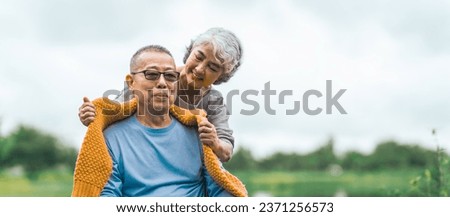 Love and support within an Asian family as they care for their elderly parents, symbolizing values of respect and devotion in aging together. Loving Care for Elderly Asian Couple in Wheelchair