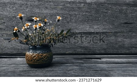 Wildflowers in a ceramic vase with oriental patterns on a wooden background