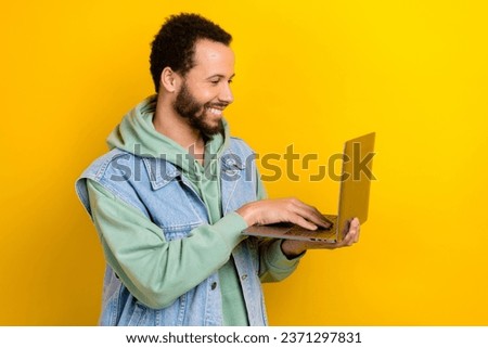 Profile photo of handsome guy beaming smile use wireless netbook coworking isolated on yellow color background