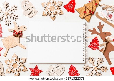 Top view of notebook on wooden background made of Christmas decorations. New Year concept.