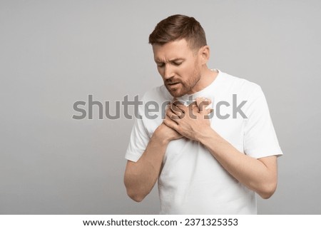 Breathing problem. Man holds on to chest suffering from heartburn. Caucasian young guy suffers from pain in sternum. Unbearable pain tearing apart chest, burning inside and suffering, acute discomfort Royalty-Free Stock Photo #2371325353