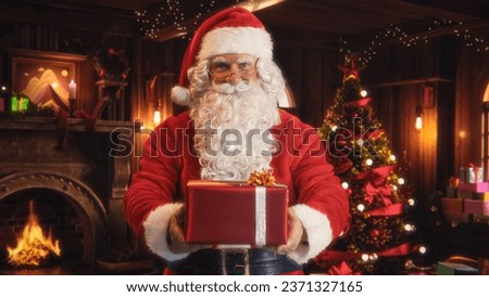 Merry Santa Claus Standing in a Magical Decorated Room, Offering Beautifully Wrapped Red Gift. Father Christmas Giving Presents to Kids. Concept of Christmas and New Year's Winter Holidays Celebration Royalty-Free Stock Photo #2371327165