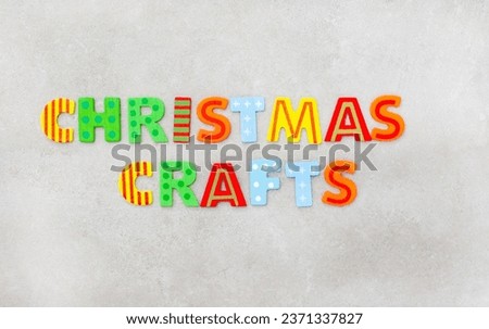 Christmas crafts in bright lettering  on a mottled grey surface