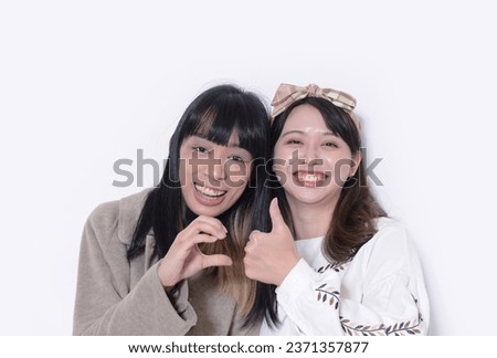 Female friends and partners. Two young women embracing and happy standing in studio