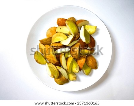closeup of a pile of fresh, sliced ​​raw jengkol on a white plate isolated on a white background ready to be cooked. top view