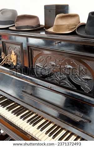 vintage, decorative piano. with vintage hats on top.