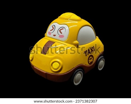 A yellow toy car smiles happily on a black background
