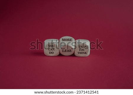 Turned dice and changes the expression you can do less than you think to you can do more than you think. Beautiful red background, copy space. Business, motivational concept.