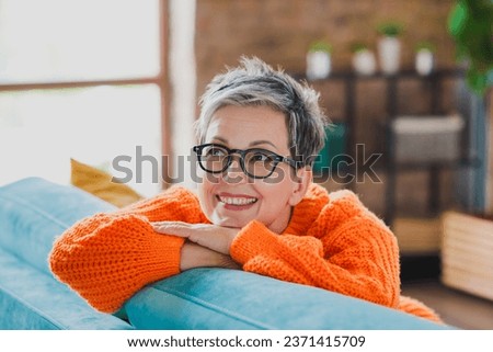 Portrait of lovely positive person sitting cozy sofa toothy smile daydreaming imagine apartment inside Royalty-Free Stock Photo #2371415709
