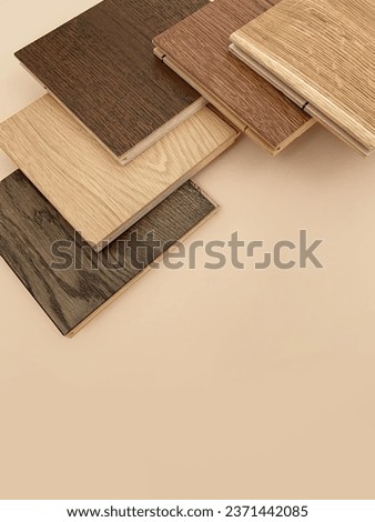 Engineered hardwood or laminate flooring swatch samples in various type of wood texture, isolated on beige background. A variety of shades of wood floor material.  Royalty-Free Stock Photo #2371442085
