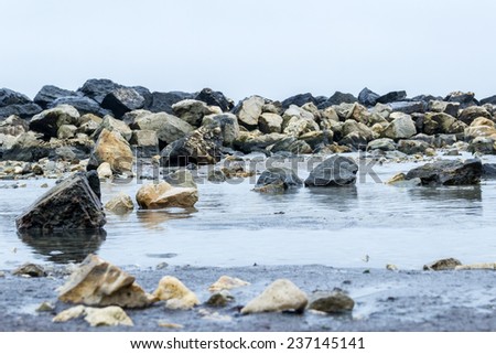Sea shallow water and yellow and black rocks