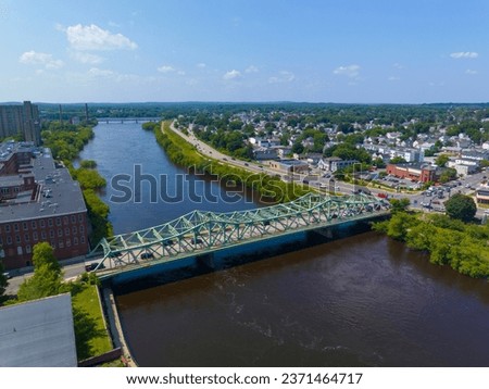 John E. Cox Memorial Bridge aerial view over Merrimack River at Lowell National Historical Park in historic downtown Lowell, Massachusetts MA, USA.  Royalty-Free Stock Photo #2371464717