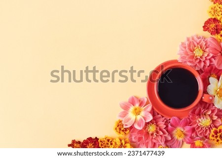 Autumn composition of a red coffee cup and dahlia flowers on a yellow background with a place for text. Flat lay. Nature concept