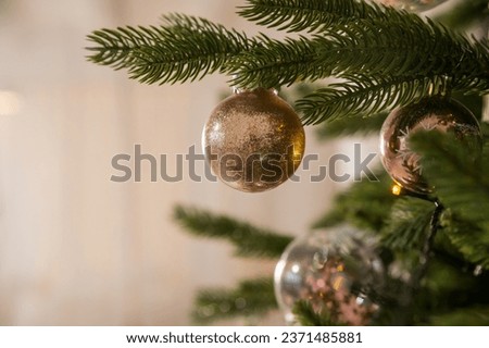 christmas tree decoration. toys and garlands. festive decor during winter holidays.Glittery ornament hangs from bough of fresh Christmas tree.Festive atmosphere.