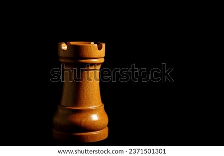 Wooden chess piece rook on dark background. Strategic placement and gameplay. Minimal intelligence and strategy concept
