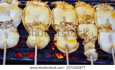 Picture of grilled squid in Thai style, eat with spicy seafood dipping sauce. Photos of street food in Thailand