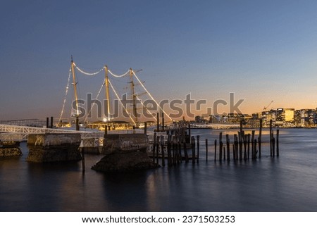 The beautiful view of the river and Boston skyline at sunset with a moored schooner. Massachusetts.