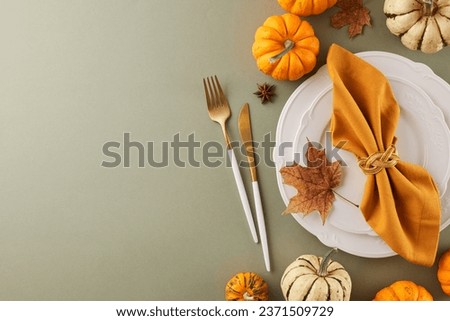 Craft a Thanksgiving table that leaves an impression. Top view shot of plates, cutlery, orange napkin, cup, ripe pumpkins, fall elements on light green background with promo panel