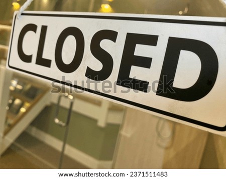 Closed shop sign hanging in a window