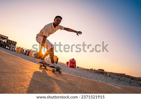 Surf skater training surfing moves near the beach at sunset. Royalty-Free Stock Photo #2371521915
