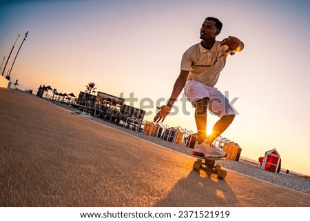 Surf skater training surfing moves near the beach at sunset. Royalty-Free Stock Photo #2371521919