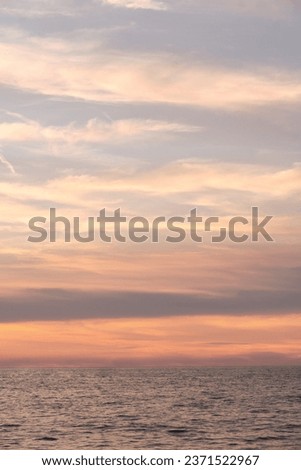 Summer evening sea landscape. The sky at sunset is filled with bright and vibrant colors, complemented by fluffy clouds. Copy space background.