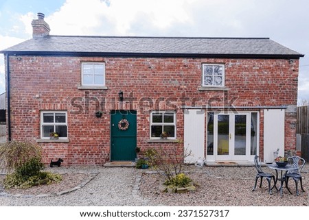 Pretty converted Irish barn house cottage with stable door and sliding barn doors. Royalty-Free Stock Photo #2371527317