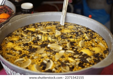 Hot compote, mulled wine made from lemon, pomegranate and various fruits in a vat