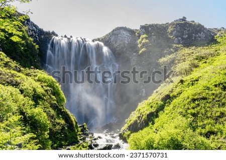 Massive wide beautiful waterfall in the middle of nature in Scotland.