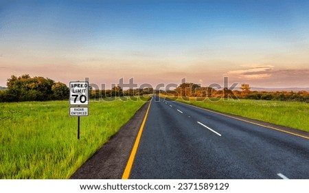 speed limit 70, enforced by radar, road sign marking on the side of the road warning drivers to slow down