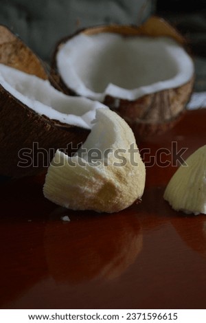 Coconut apple or coconut bread cut on rustic wooden board. Spongy white fruit known as cut coconut kernels. Maçã do côco 