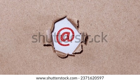 Email symbol on the back of torn brown paper.
