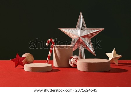 Minimal scene for products showcase with Christmas concept. Stars, candy cane and baubles decorated with cylinder podiums on black and red background. Space for display product Royalty-Free Stock Photo #2371624545