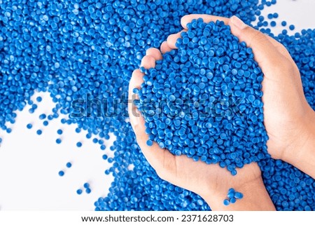 White plastic grain, plastic polymer granules,hand hold Polymer pellets, Raw materials for making water pipes, Plastics from petrochemicals and compound extrusion, resin from plant polyethylene. Royalty-Free Stock Photo #2371628703