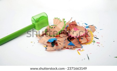 Green pencils and shavings on a white background with colorful pencil shavings. Whole and broken lead pencils on white background. The rest of the pencil. Macro, pile of shavings