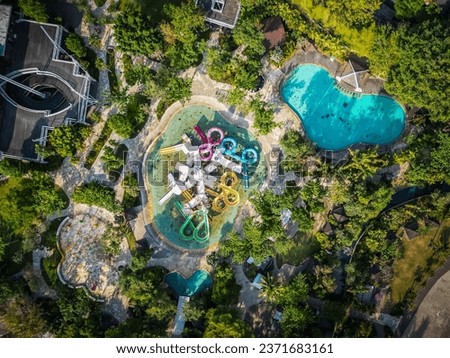Aerial view of Jogja Bay Pirates Adventure Waterpark (JBW) is a water adventure tourism destination with a pirate theme. Waterboom with large colorful spiral slide and swimming pool. Royalty-Free Stock Photo #2371683161