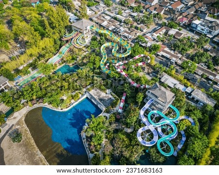 Aerial view of Jogja Bay Pirates Adventure Waterpark (JBW) is a water adventure tourism destination with a pirate theme. Waterboom with large colorful spiral slide and swimming pool.