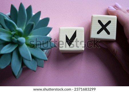 Yes vs No symbol. Businessman hand is making a choice between YES and No symbol. Beautiful pink background with succulent plant. Business concept. Copy space.