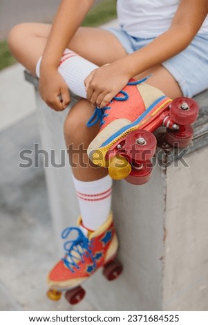 Teenage girl in high white socks and retro roller skates. Close up of roller skates.